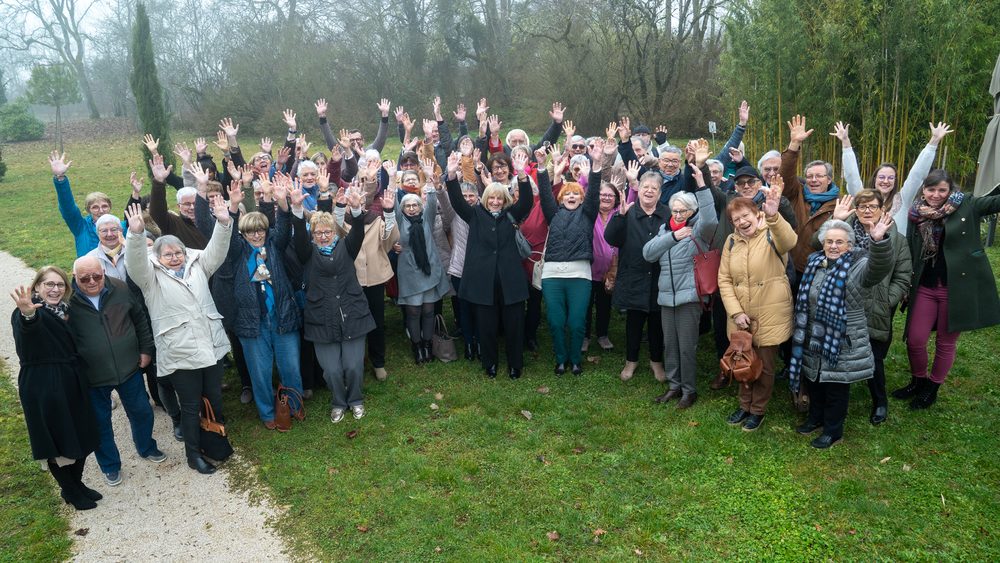 Groupe de bénévoles et salariés ADMR, bras levés et souriants