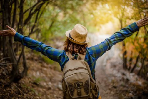 Randonneuse les bras levés en forêt